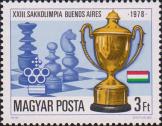 Кубок победителя, эмблема команды Венгрии на фоне шахматных фигур и доскию Государственный флаг Венгрии и памятный текст