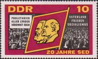 Знамя с портретами К. Маркса и В. И. Ленина. Демонстранты с лозунгами «Пролетарии всех стран, соединяйтесь!» и «Отечество, мир, социализм»