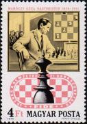 Гроссмейстер Геза Мароци (1870-1951) за шахматным столиком, в овале - король.