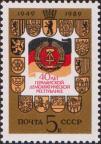 Государственные герб и флаг ГДР в «окне», обрамленном гербами 15 округов страны 