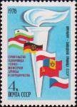 Государственные флаги стран - участниц совместных работ (НРБ, ВНР, ГДР, ПНР, СРР, СССР и ЧССР) на фоне символического факела 
